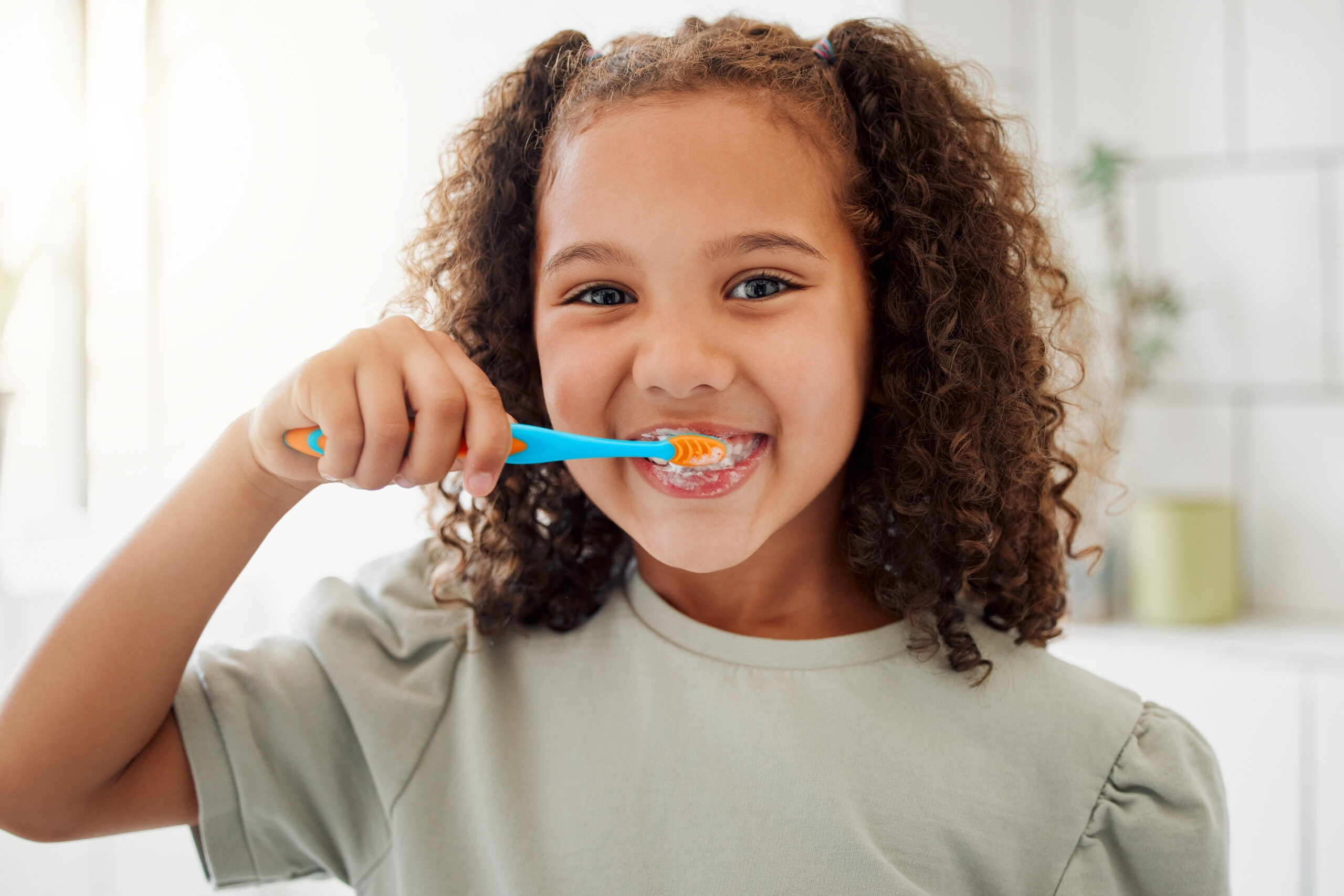 Child brushing teeth in bathroom.